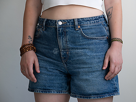 Beyond The Frame: Junge Perspektiven auf Vielfalt im Glauben - Frau trägt Shorts, Mala und Segenarmband