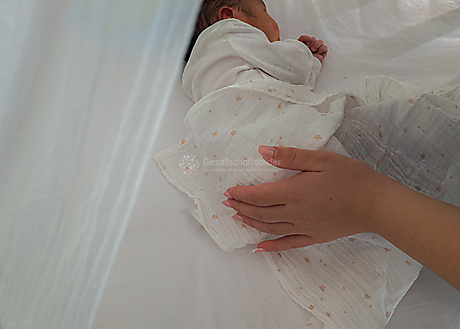 Beyond The Frame: Junge Perspektiven auf Vielfalt im Glauben - Das Neugeborene wird von Khaliqs Frau gestreichelt